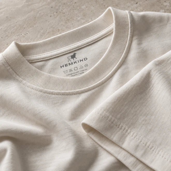 Detail van de ronde hals en schoudernaden van het ivoorkleurige alledaagse T-shirt.